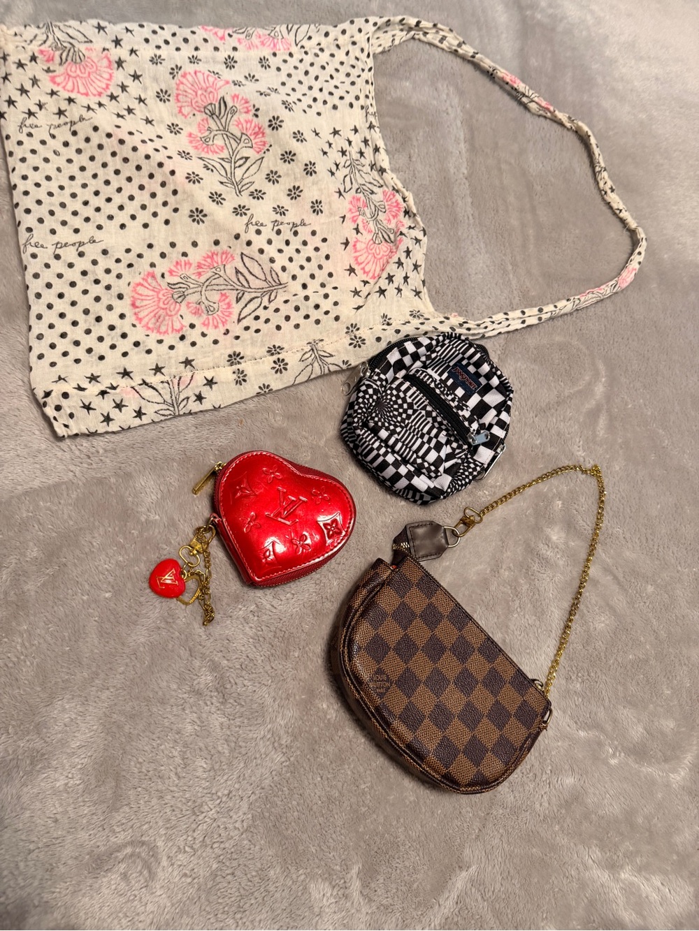 Bundle heart-shaped coin purse and a monogrammed Damier Ebène canvas pochette.